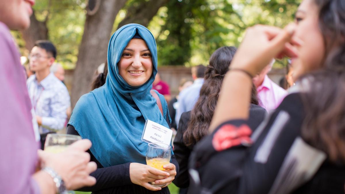 a woman in a hijab participates in a banquet outdoors